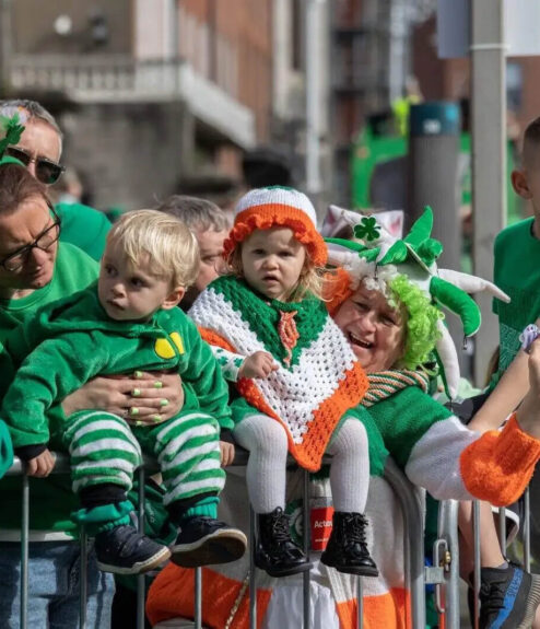 Families in festive green enjoying a St. Patrick’s Day parade in Dublin.