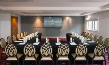 Elegant conference room at Louis Fitzgerald Hotel, set for a meeting with stylish chairs.