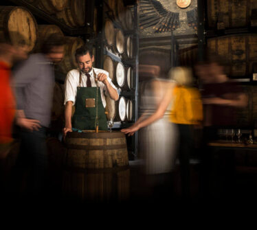 Bartender serves guests in cosy whisky barrel room at Louis Fitzgerald Hotel, Dublin.