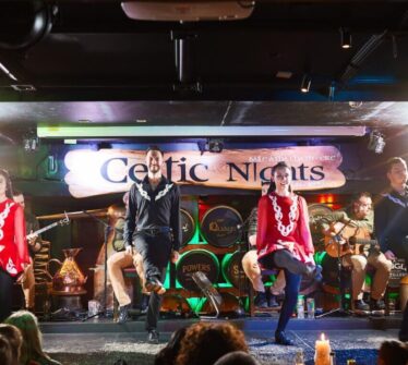 Irish dancers performing lively steps on stage at Louis Fitzgerald Hotel's Celtic Nights.