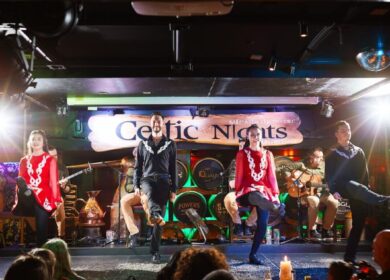 Irish dancers performing lively steps on stage at Louis Fitzgerald Hotel's Celtic Nights.