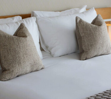 Elegant hotel room with plush pillows and crisp white linens at Louis Fitzgerald Hotel.
