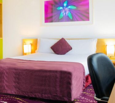 Cosy hotel room with purple accents and modern decor at Louis Fitzgerald Hotel, Dublin.