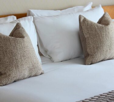 A cosy bed with soft pillows in a luxury hotel room at Louis Fitzgerald Hotel, Dublin.