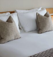 Luxurious king bed with soft pillows in a cosy hotel room at Louis Fitzgerald Hotel, Dublin.