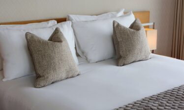 Luxurious king bed with soft pillows in a cosy hotel room at Louis Fitzgerald Hotel, Dublin.