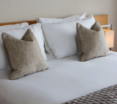 Luxurious king bed with soft pillows in a cosy hotel room at Louis Fitzgerald Hotel, Dublin.