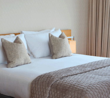 Elegant hotel room with plush pillows and quilted bedding at Louis Fitzgerald Hotel, Dublin.