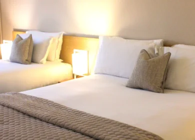 Cosy twin beds with soft lighting in a welcoming hotel room.