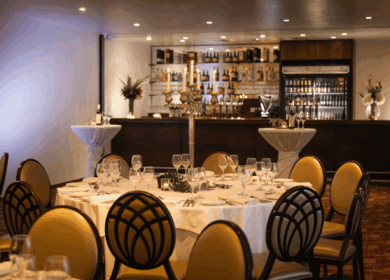 Elegant dining area at Louis Fitzgerald Hotel with set tables and warm lighting.