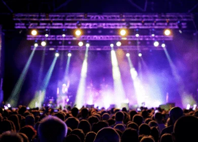 Crowd enjoying a vibrant concert with colourful stage lights.