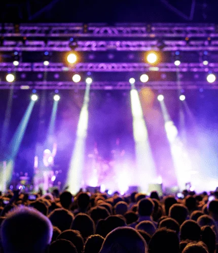 Crowd enjoying a vibrant concert with colourful stage lights.