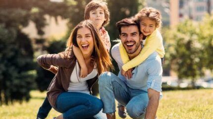 Happy family enjoying a sunny day outdoors on the hotel grounds.