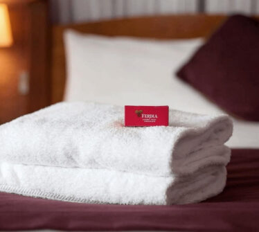 Luxurious hotel room with fresh towels and a cosy bed at Louis Fitzgerald Hotel, Dublin.