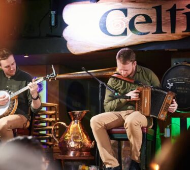 Musicians playing traditional Irish instruments at a cosy pub.