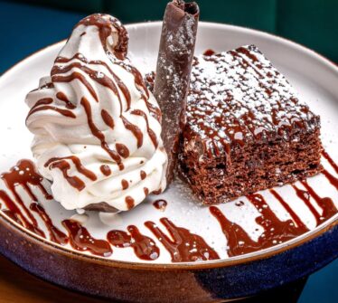 Delicious chocolate dessert with creamy swirl and drizzle at Louis Fitzgerald Hotel.