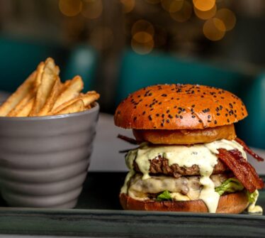 Delicious gourmet burger with fries at Louis Fitzgerald Hotel.