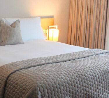 Cosy hotel room with a double bed, soft lighting, and elegant curtains at Louis Fitzgerald Hotel.