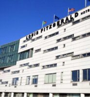Modern facade of Louis Fitzgerald Hotel in Dublin with blue sky backdrop.