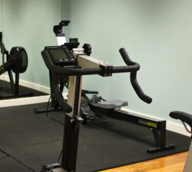 Modern gym with exercise bike and rowing machine at Louis Fitzgerald Hotel.