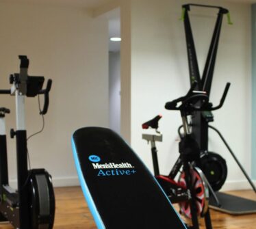 Hotel fitness room with exercise bikes and mirrors.