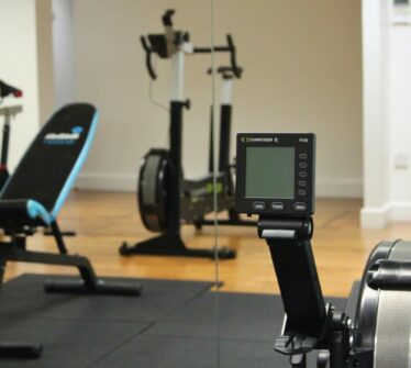 Modern gym with rowing machines and exercise bike at Louis Fitzgerald Hotel.