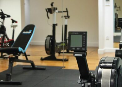 Modern gym with rowing machines and exercise bike at Louis Fitzgerald Hotel.