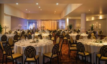 Elegant banquet hall with round tables set for an event at Louis Fitzgerald Hotel, Dublin.