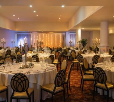 Elegant banquet hall with round tables set for an event at Louis Fitzgerald Hotel, Dublin.