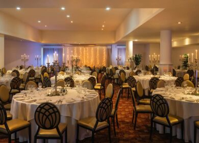 Elegant banquet hall with round tables set for an event at Louis Fitzgerald Hotel, Dublin.