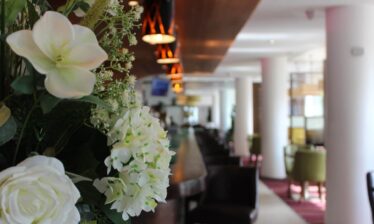 Elegant hotel lobby with floral decor and ambient lighting.