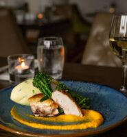 Elegant dining table setting with gourmet meal and wine at Louis Fitzgerald Hotel in Dublin.