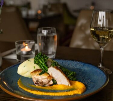 Elegant dining table setting with gourmet meal and wine at Louis Fitzgerald Hotel in Dublin.