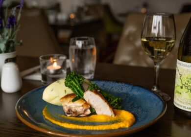 Elegant dining table setting with gourmet meal and wine at Louis Fitzgerald Hotel in Dublin.