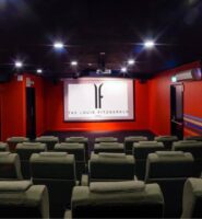 Comfortable theatre room at Louis Fitzgerald Hotel with plush seats and dim lighting.