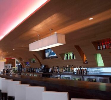 Elegant hotel bar with a modern design, showcasing a wide selection of drinks.