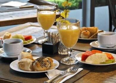 Elegant breakfast setup at Louis Fitzgerald Hotel with juice, coffee, pastries, and fruit.