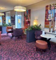 Cosy hotel lobby with colourful seating and vibrant artwork at Louis Fitzgerald Hotel.