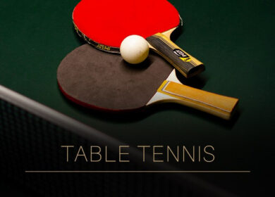 Two table tennis paddles and a ball on a green table.