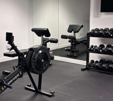 Modern hotel gym with exercise bike and weights rack in Dublin.