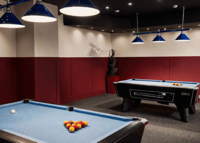 Pool tables in a stylish games room with blue lights at Louis Fitzgerald Hotel, Dublin.