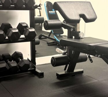 Modern gym facilities at Louis Fitzgerald Hotel, featuring weights and exercise equipment.