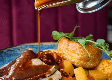 Succulent roast beef with gravy, served with Yorkshire pudding and roasted vegetables.