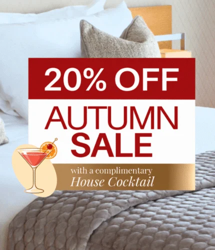 Elegant hotel room with cosy bedding and seasonal sale offer for autumn guests.